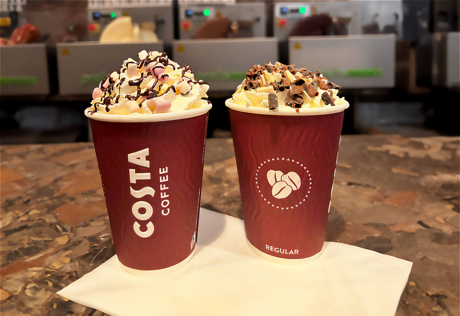 Two cups of hot chocolate milk from Belgian chocolate with extra toppings.